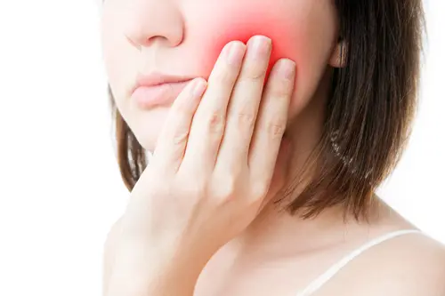 歯が痛み口元を抑える女性
